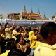 People wearing yellow, a color associated with both the current monarch and his father, cheer as the motorcade carrying king Maha Vajiralongkorn and queen Suthida drives past the Grand Palace in Bangkok.